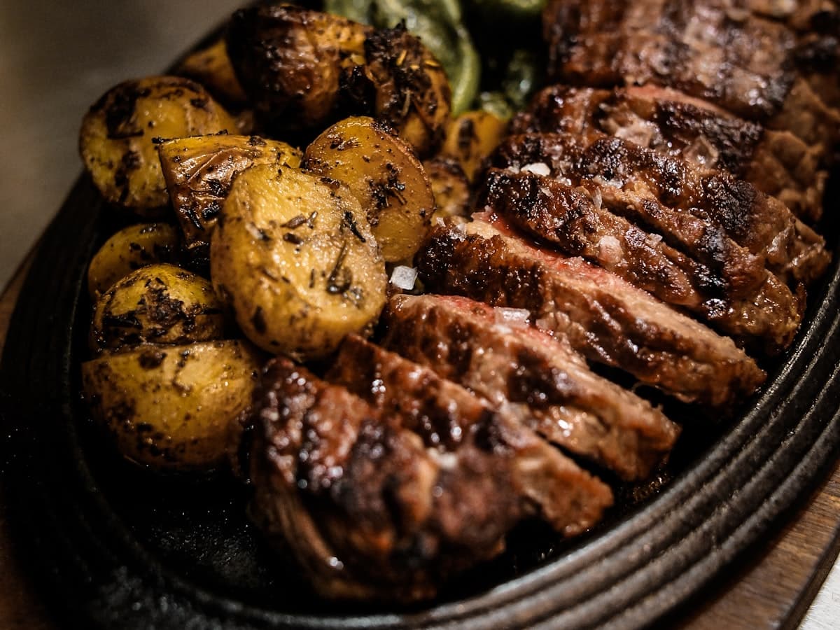 Lomo de retinto a la brasa con patatas y pimientos de Padrón