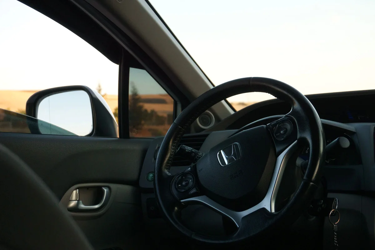 Interior del coche de prácticas con el salpicadero y la calle al fondo
