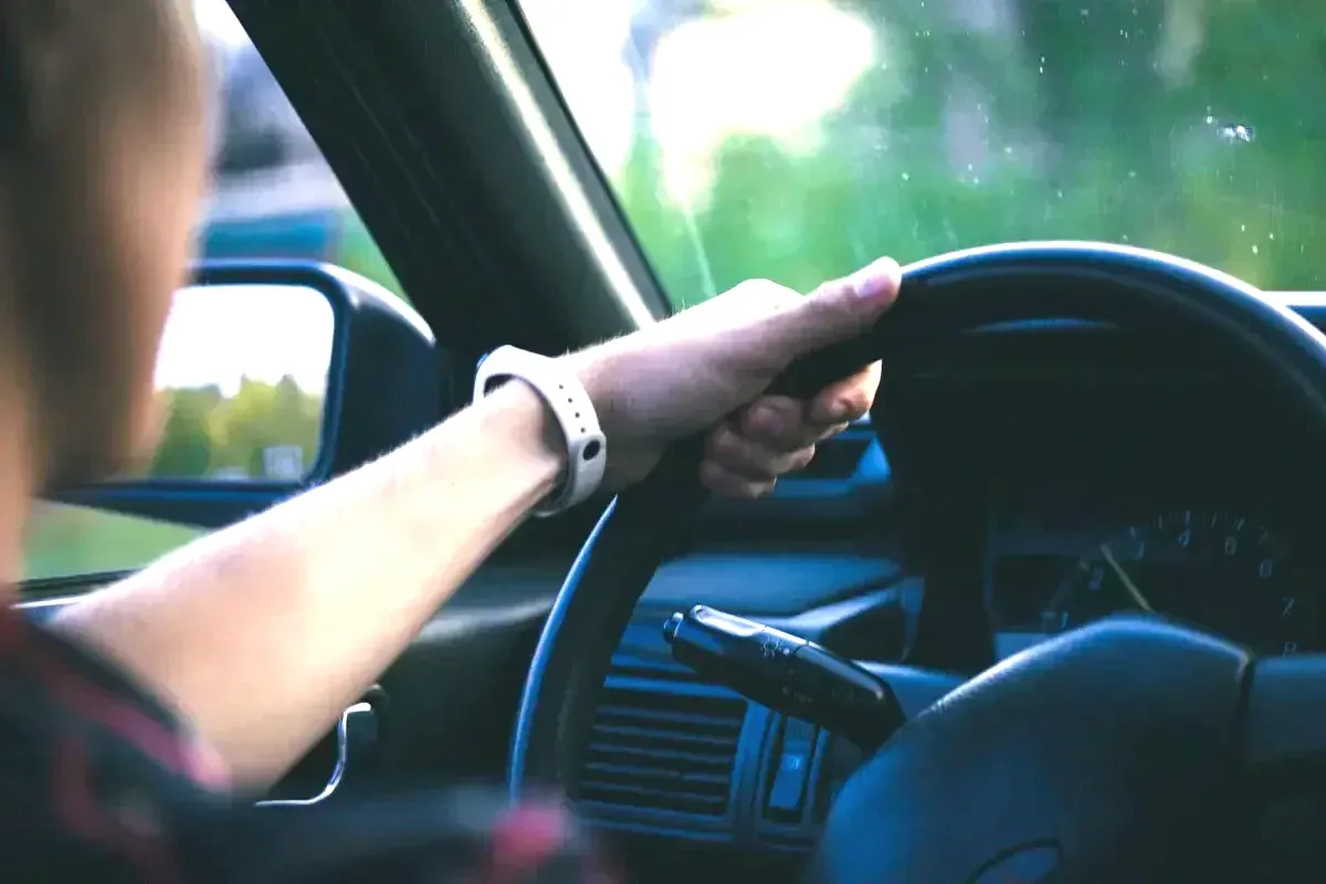 Mano sobre el volante con el salpicadero al fondo
