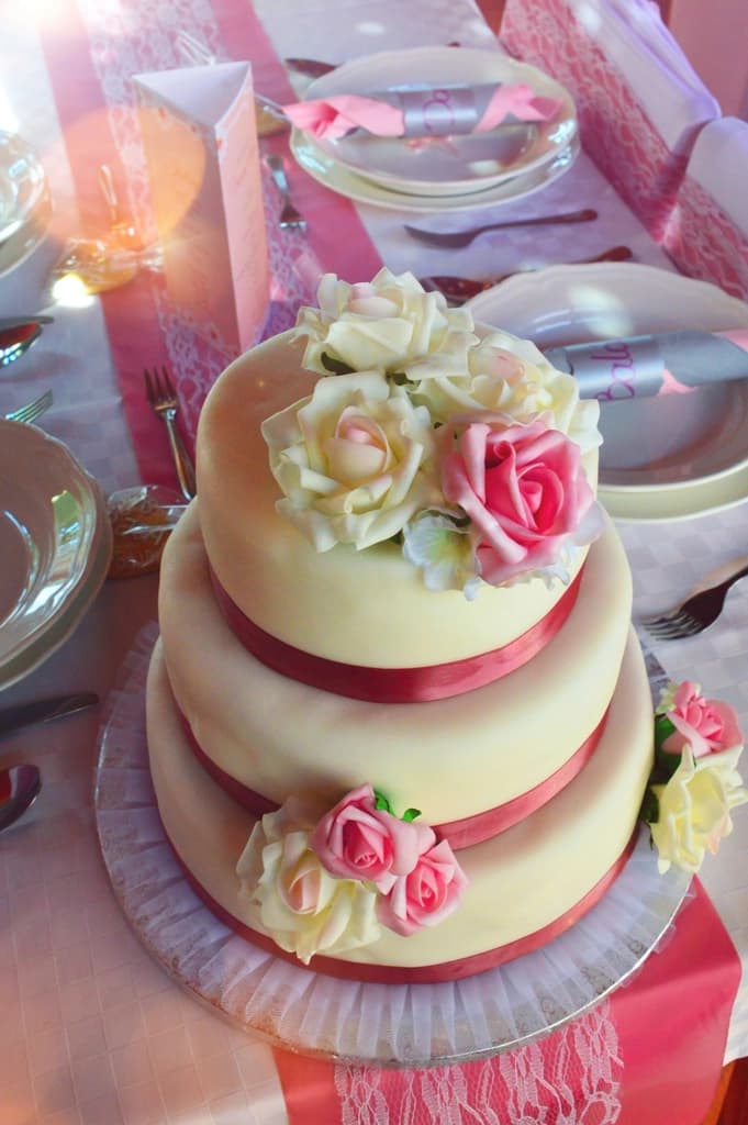Tarta de boda de tres pisos decorada con rosas
