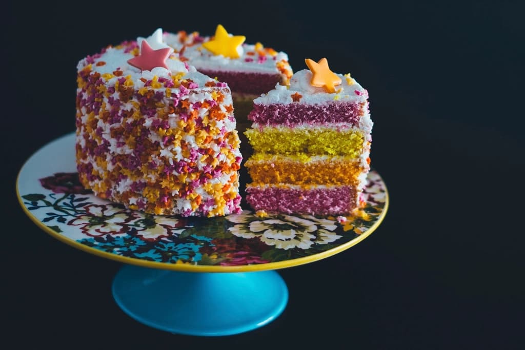 Tarta de capas de colores cubierta de estrellas de azúcar