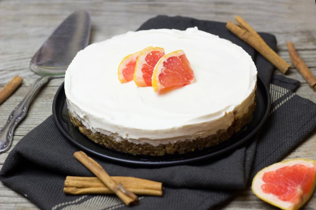 Tarta de queso con pomelo sobre mesa gris