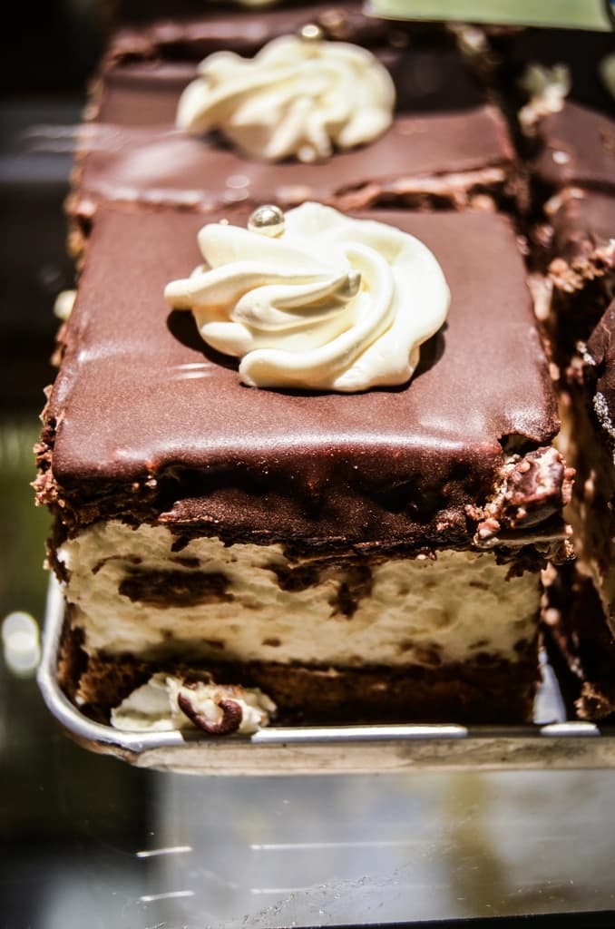 Tarta de queso bañada en chocolate negro con nata montada