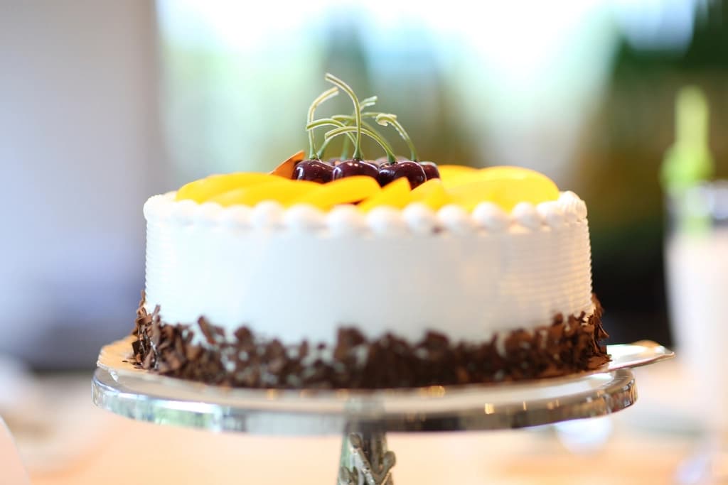Tarta chiffon de vainilla cubierta de mango y guindas