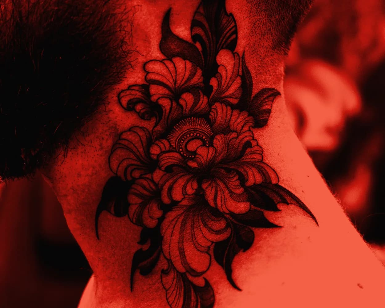 Flor de negro sólido curada en el lateral del cuello, con el borde duro y el relleno mate