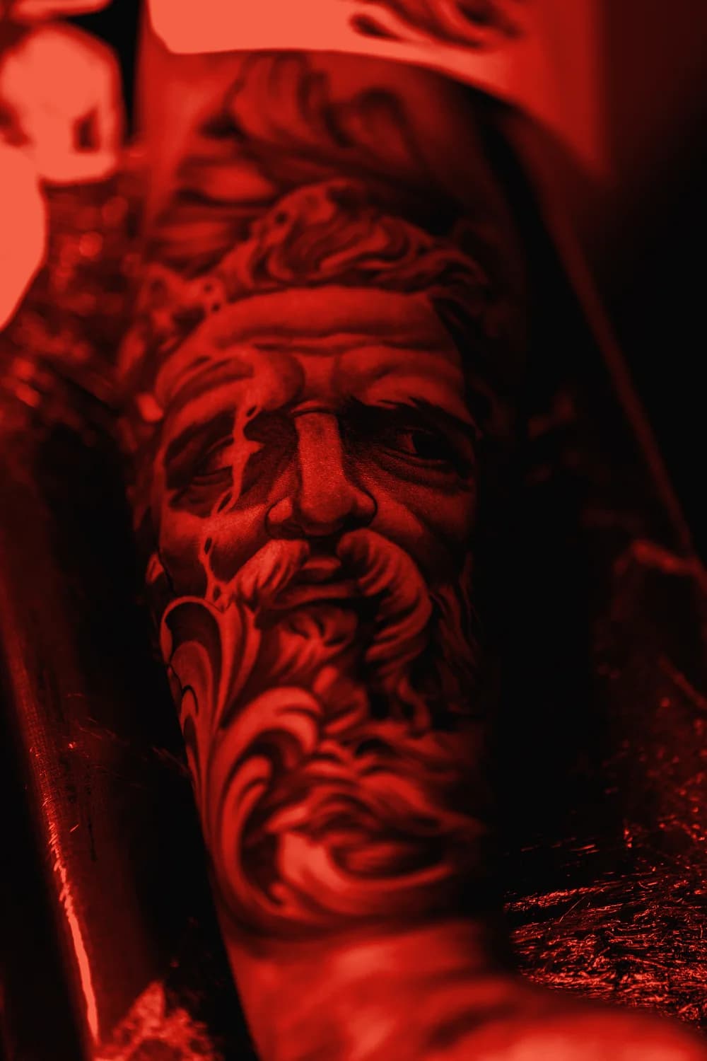 Rostro de Zeus en microrrealismo sobre el brazo: sombra sin contorno, ya curado